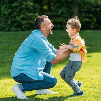 father and son playing outside in front yard