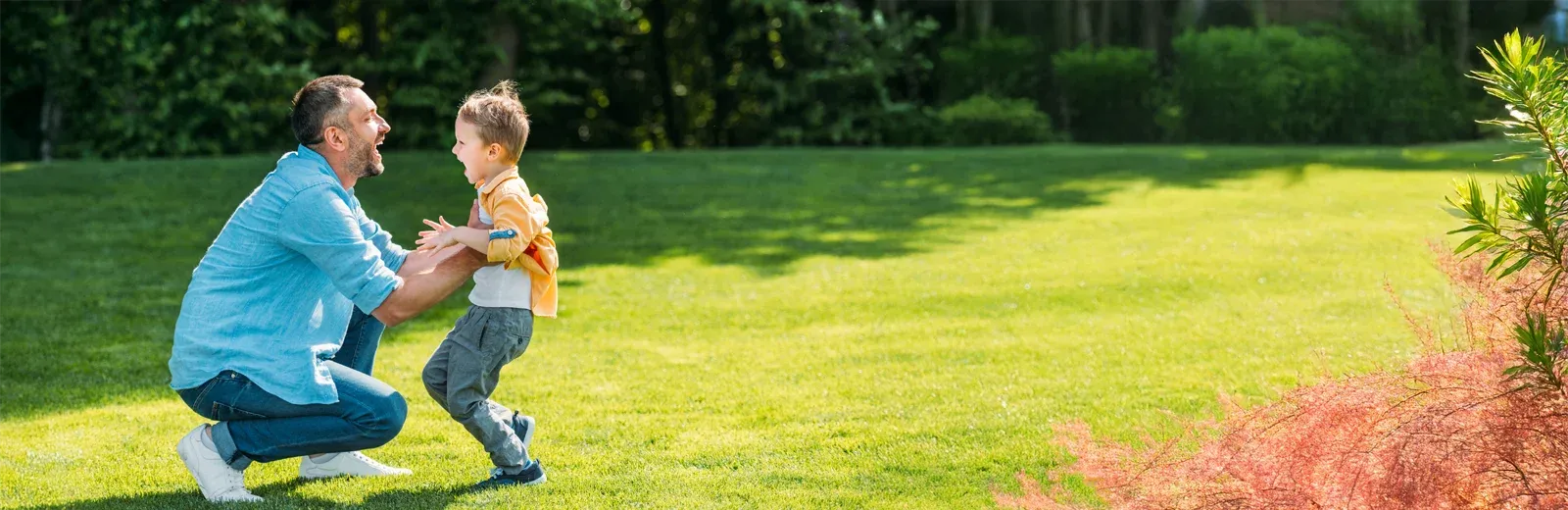father and son playing outside in yard